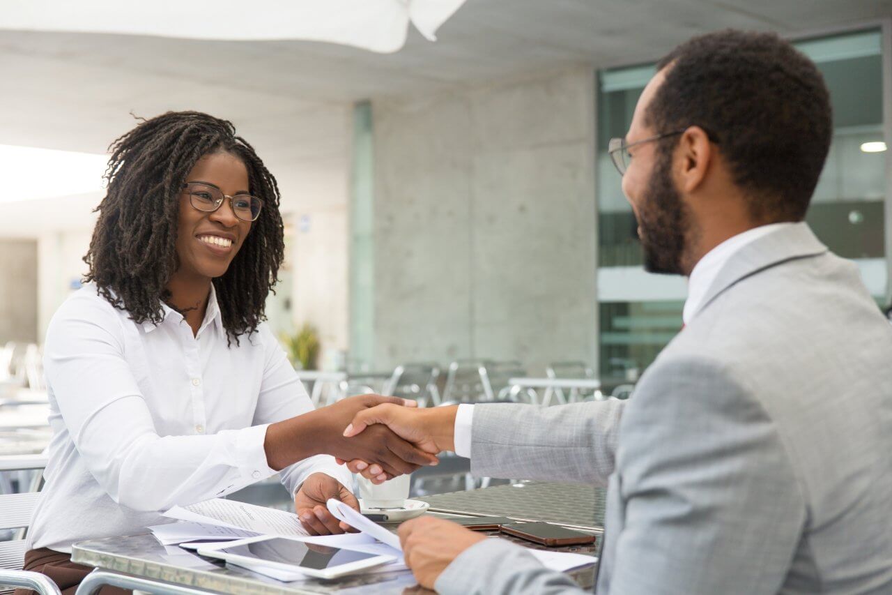 Two people shaking hands, smiling, symbolizing successful debt removal process
